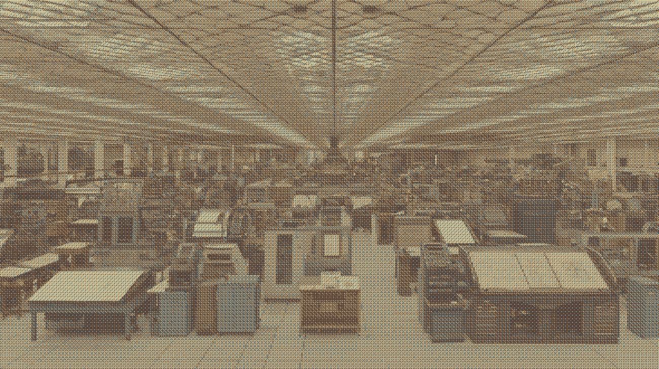 A machine shop floor seen down the length of the building, as a dithered print.